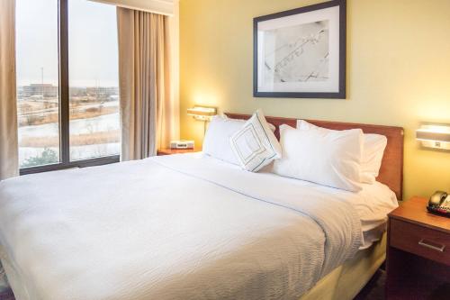 a hotel room with a large bed with a window at SpringHill Suites by Marriott Chicago Southwest at Burr Ridge Hinsdale in Burr Ridge