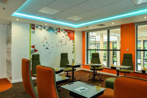 a conference room with chairs and tables and a wall with at Radisson Blu Manchester Airport in Hale