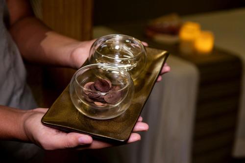 a person holding a glass bowl with chocolate on a plate at Santa Marta Marriott Resort Playa Dormida in Santa Marta