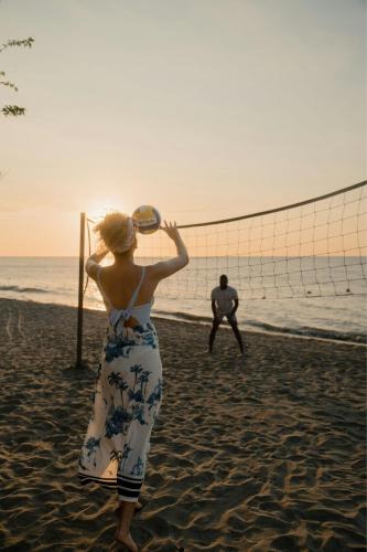 a woman playing a game of volleyball on the beach at Santa Marta Marriott Resort Playa Dormida in Santa Marta