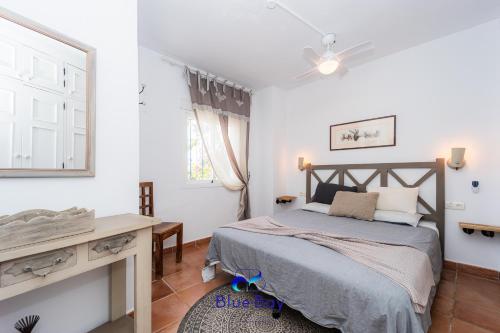 a bedroom with a bed and a desk and a mirror at Casa Tropical in La Herradura