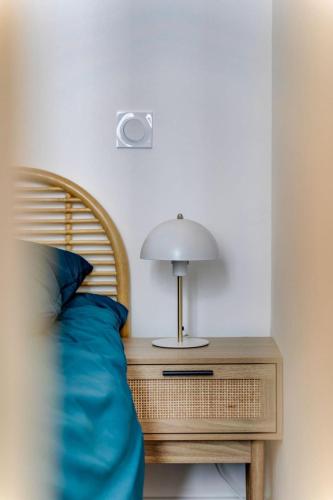- un lit avec un oreiller bleu et une lampe sur une table dans l'établissement La suite Impériale - Hypercentre, à Toulouse
