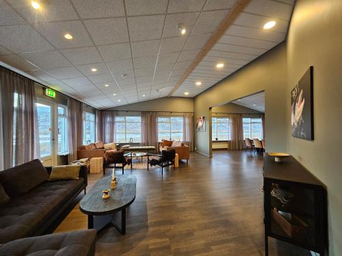 a living room with couches and tables and chairs at Long Valley Lodge in Þingeyrar