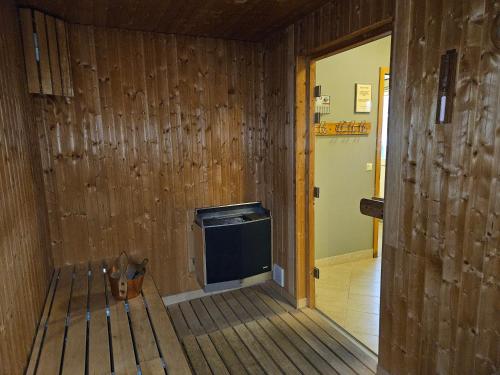 a room with a wooden wall with a tv in it at Long Valley Lodge in Þingeyrar