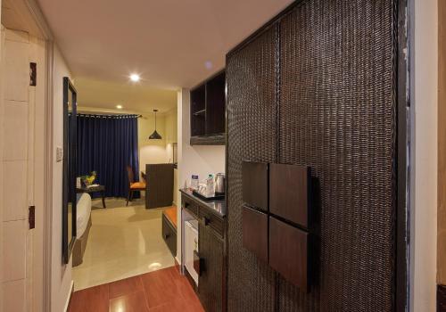 a kitchen with a door to a living room at Tulip Inn Koramangala Bangalore in Bengaluru