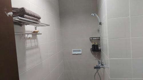 Klandasan KecilJust Cozy Apartemen Borneo Bay 1 BR dan 2 BR的白色瓷砖浴室配有淋浴