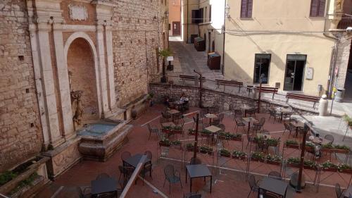 an empty courtyard with tables and chairs in a building at The Angela's House and large balcony on the square in Todi