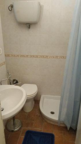 a bathroom with a white toilet and a sink at The Angela's House and large balcony on the square in Todi
