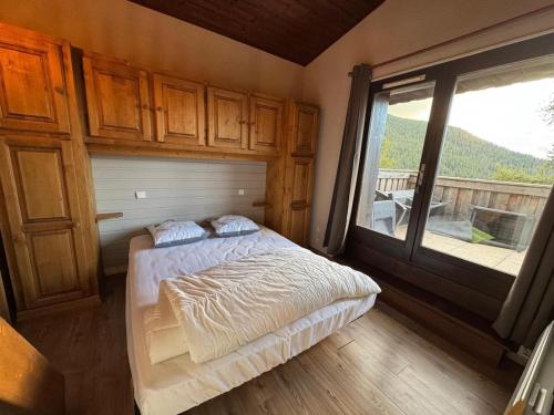 une chambre avec un lit et une grande fenêtre dans l'établissement Renovated Duplex Apartment - 8 guests, aux Orres