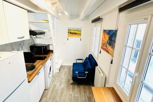 - une petite cuisine avec une chaise bleue dans une petite maison dans l'établissement Dream Dwell Paris-Apart at the heart of 3e Marais District, à Paris