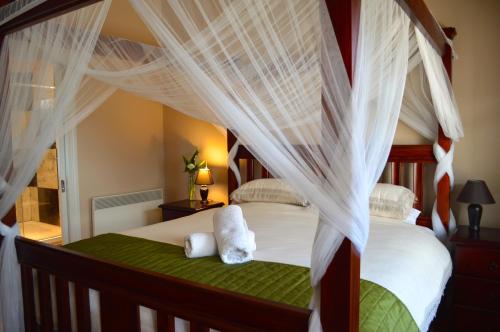 a bedroom with a canopy bed with teddy bears on it at Little River Bed and Breakfast in Little River