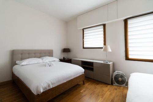 une chambre avec un lit et un bureau et deux fenêtres dans l'établissement Appartement 2 personnes proche Beaugrenelle - II, à Paris