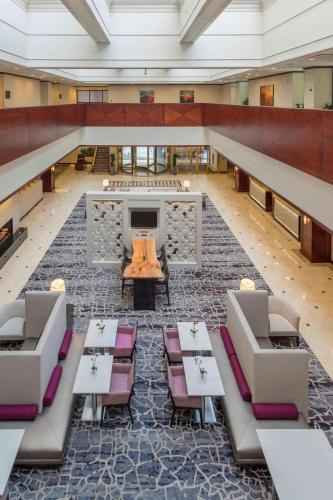 an empty lobby with tables and chairs and a tv at Salt Lake Marriott Downtown at City Creek in Salt Lake City