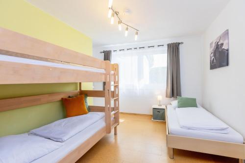 deux lits superposés dans une chambre avec fenêtre dans l'établissement Moderne Fewo mit Fasssauna und Kamin im ländl. Allgäu, à Eggenthal