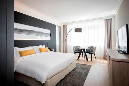 a hotel room with a large bed and a table at Lyon Marriott Hotel Cité Internationale in Lyon