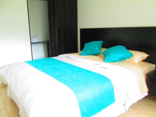 a large white bed with blue pillows on it at Ocean Blue Hotel in Olón