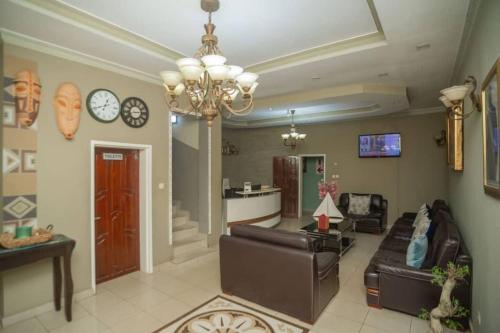 a living room with a couch and a chandelier at Large Room with Free Breakfast in Lubumbashi