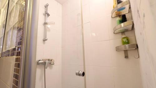 une salle de bain avec une douche avec une porte vitrée dans l'établissement 02 grand studio near montorgueil, à Paris
