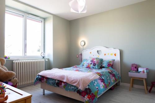 une chambre avec un lit avec un couvre-lit fleuri dans l'établissement Magnifique maison individuelle avec piscine, à Langogne