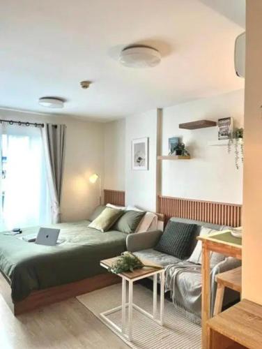 a living room with a bed and a couch at Elio Sukhumvit 64: Chic Space in Bangkok
