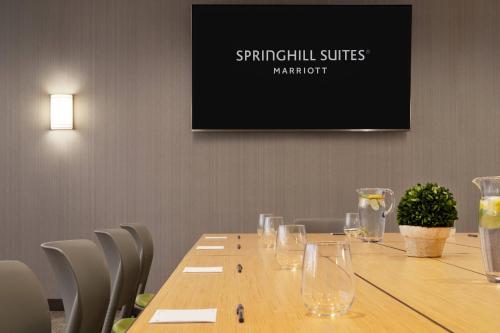 a long wooden table with wine glasses on it at SpringHill Suites by Marriott Allentown Bethlehem/Center Valley in Center Valley