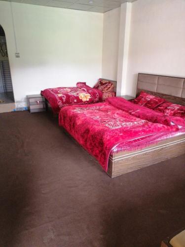 two beds in a room with red sheets on them at 4 Season Hotel and suites Malam Jabba in Malam Jabba