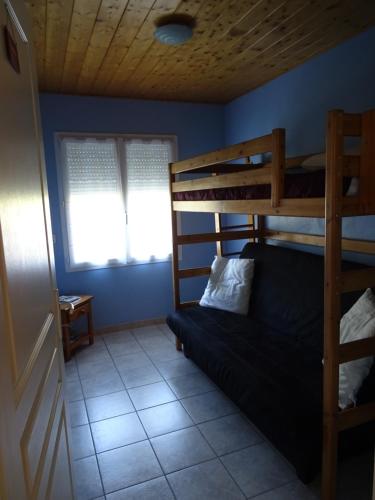 - une chambre avec des lits superposés et un canapé dans l'établissement Gîte des amandiers, à La Robine