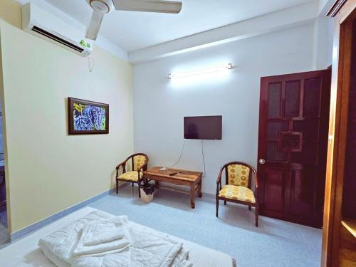 a bedroom with a bed and two chairs and a tv at Tài Phong in Ho Chi Minh City