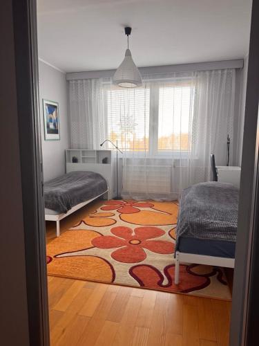 a bedroom with two beds and a rug on the floor at Apartment BU15 in Trnava