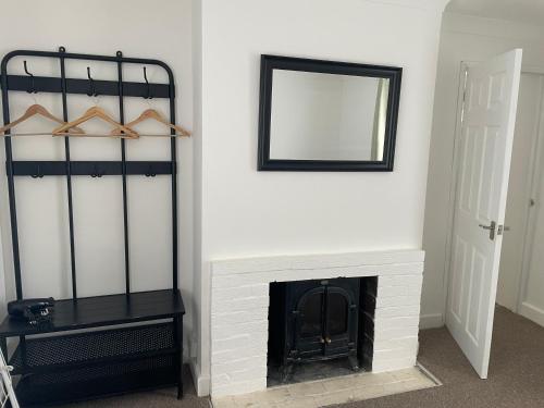 a living room with a fireplace and a mirror at Cambridge Water House Apartments in Cambridge