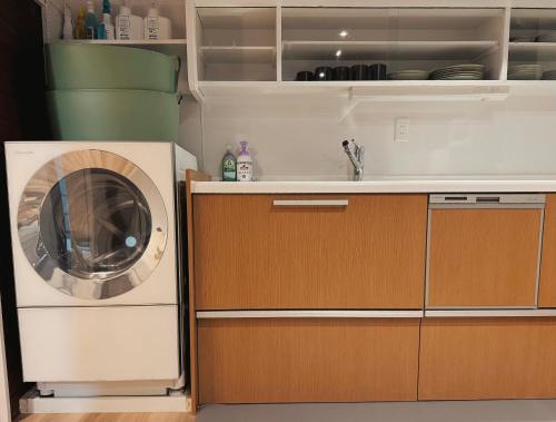 a kitchen with a washing machine in a kitchen at LoveAsakusaBigSpaceModernHome 浅草寺6分 浅草寺駅10分 2-8人 成田&羽田空港直通 in Tokyo