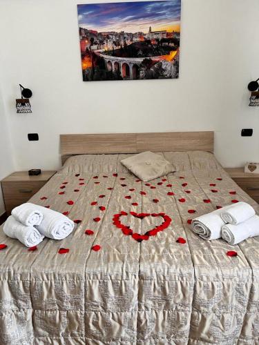 a bed with red roses on top of it at La Gravina in Gravina in Puglia