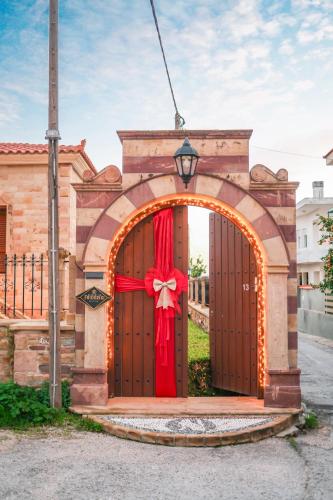 a gate with a red bow in front of a house at Archontiko Frideriki Luxury Apartments in Chios