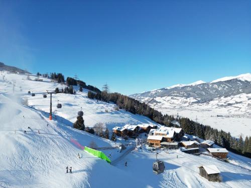 a snow covered ski slope with a ski resort at CHALET VILLAGE ZAGLGUT Wellness & Views with Summer Card Included in Kaprun