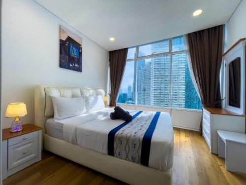sypialnia z dużym łóżkiem i dużym oknem w obiekcie Vortex Suites klcc By Sky House w Kuala Lumpur