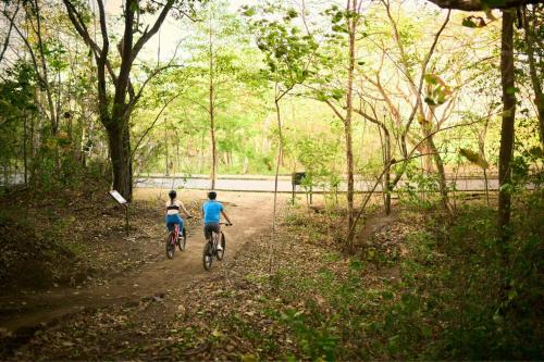 two people riding bikes down a dirt road at The Westin Reserva Conchal, an All-Inclusive Golf Resort & Spa in Playa Conchal