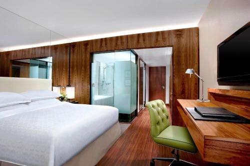 a bedroom with a bed and a desk with a television at Sheraton Grand Hotel & Spa in Edinburgh