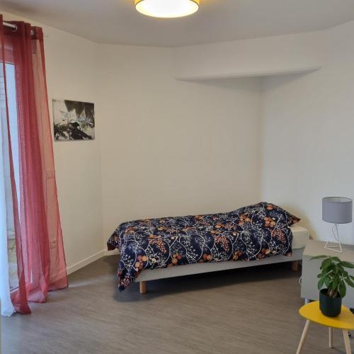 - une chambre avec un lit et une couverture fleurie dans l'établissement Résidence NOVAGE - Amiens, à Amiens