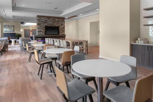 a dining room with tables and chairs and a fireplace at Residence Inn by Marriott Virginia Beach Town Center in Virginia Beach
