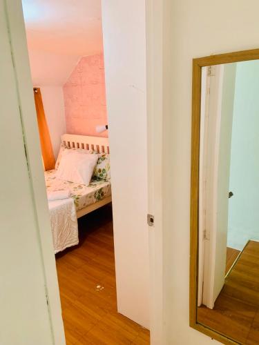 a small bedroom with a bed and a mirror at A's Place - Large, 2 Bedroom Close to the Airport! in Sibulan