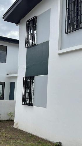 a white building with black barred windows on it at Lubrin Townhouse in San Pablo