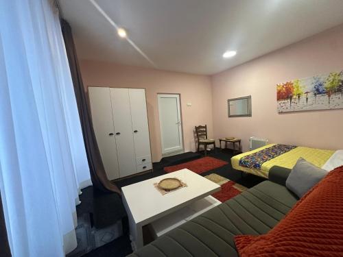 a room with a couch and a bed and a table at Comfort Studio Prishtina City Centre in Pristina