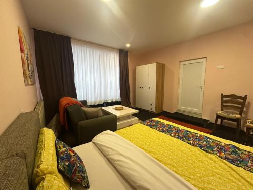 a hotel room with two beds and a chair at Comfort Studio Prishtina City Centre in Pristina
