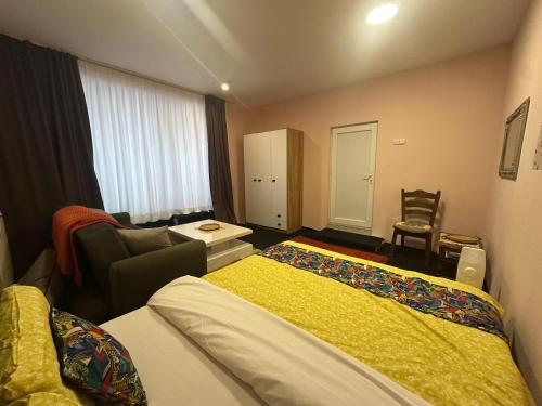 a hotel room with two beds and a living room at Comfort Studio Prishtina City Centre in Pristina