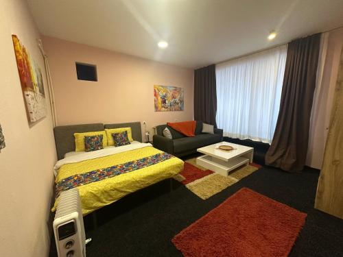 a hotel room with a bed and a couch at Comfort Studio Prishtina City Centre in Pristina