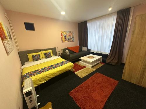 a hotel room with a bed and a couch at Comfort Studio Prishtina City Centre in Pristina