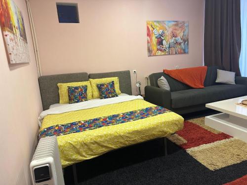 a bedroom with a bed and a couch at Comfort Studio Prishtina City Centre in Pristina