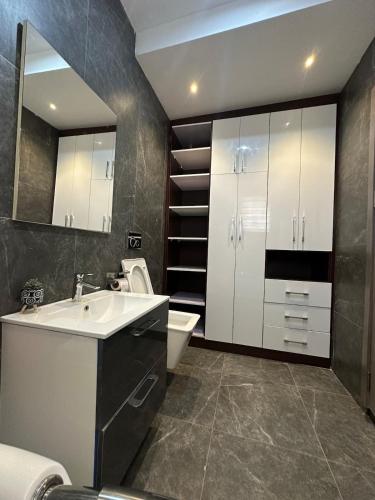 un bagno con lavandino, WC e specchio di the Greenacre a Accra