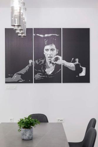 a dining room with four pictures of a man holding a gun at Ramo Luxury Villa in Kremasti