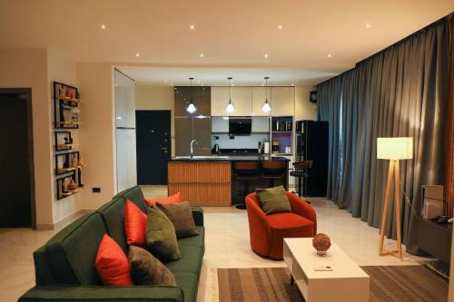 un soggiorno con un divano verde e sedie arancioni di the Greenacre a Accra